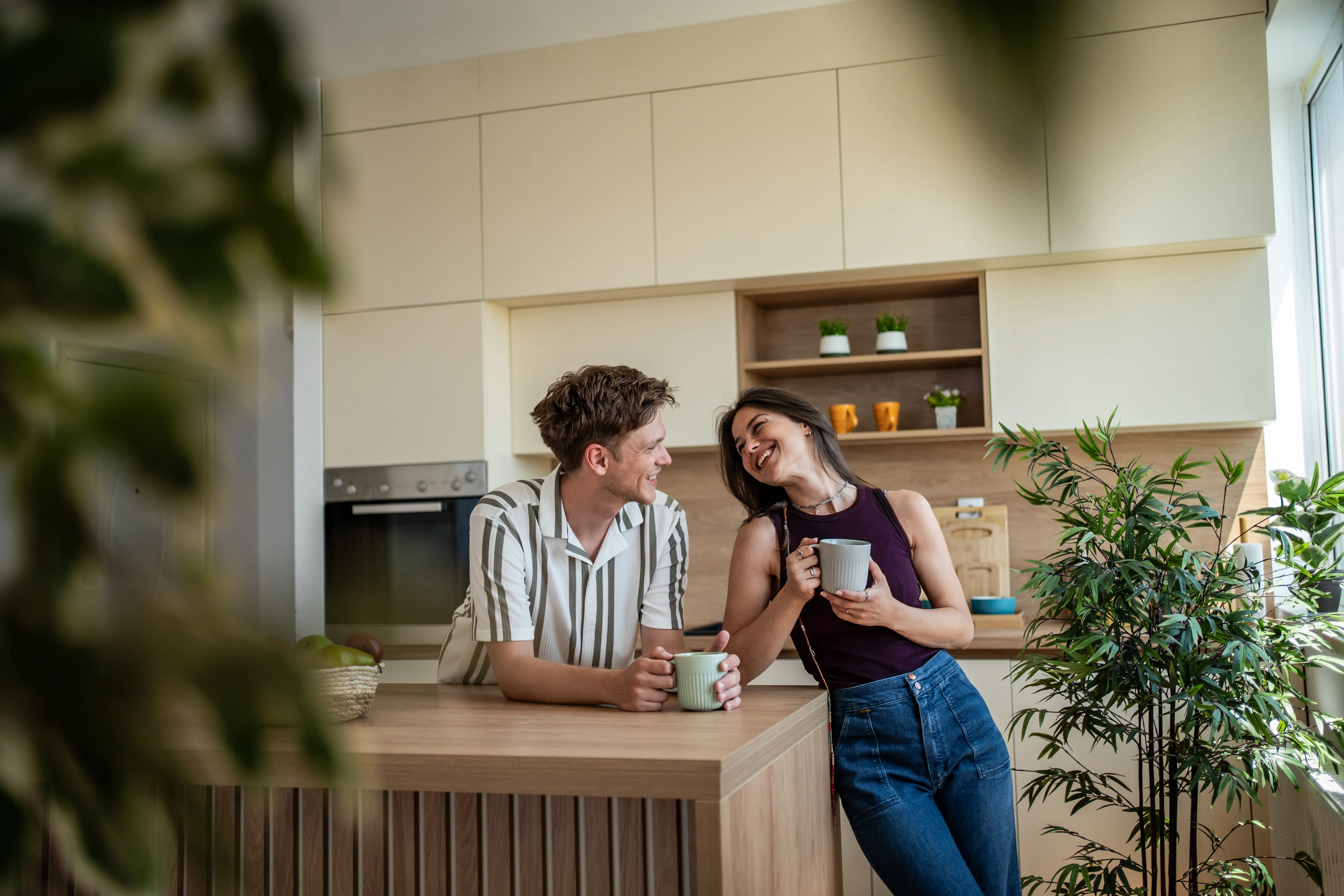 A young couple having coffee in the kitchen of their first home