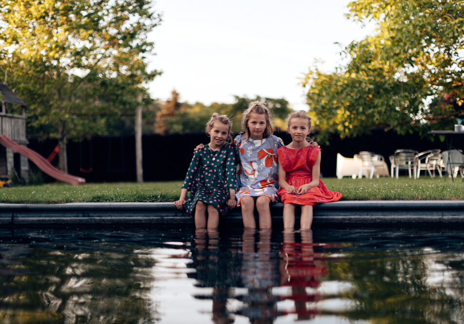 Young,Little,Sisters,Having,Fun,Sitting,At,Pool,Side,Outdoor