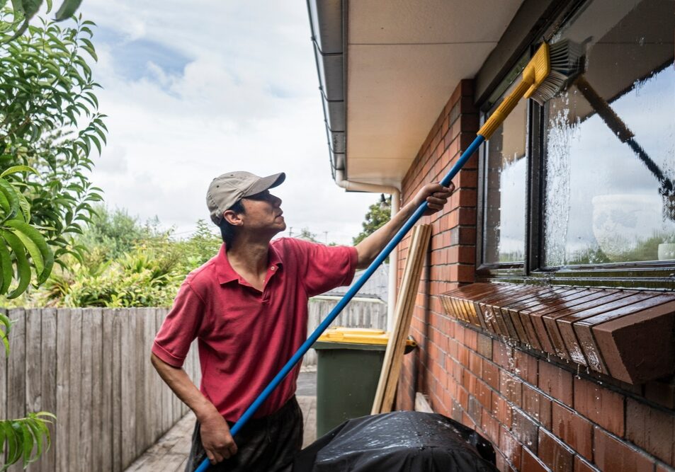 Man Spring cleaning house windows.